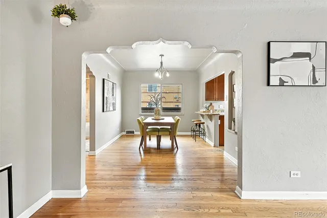 a living room with furniture and a large mirror with wooden floor