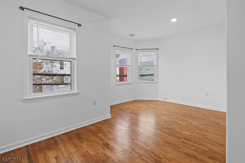 362 1/2 New Street, Unit 2 Newark, NJ 07103 - Photo 16 of 24 an empty room with wooden floor and windows