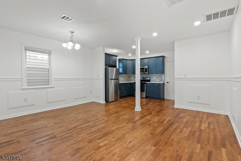 362 1/2 New Street, Unit 2 Newark, NJ 07103 - Photo 7 of 24 an empty room with wooden floor and kitchen kitchen