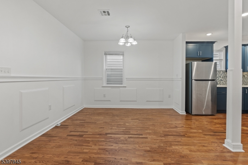 362 1/2 New Street, Unit 2 Newark, NJ 07103 - Photo 8 of 24 a view of a livingroom with wooden floor and a refrigerator
