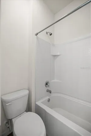 a white toilet and tub sitting next to a bathroom sink