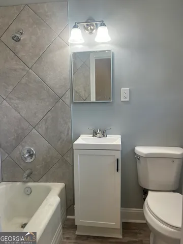 a bathroom with a sink mirror vanity and toilet