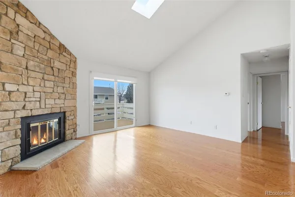 a view of an empty room with a fireplace and a window