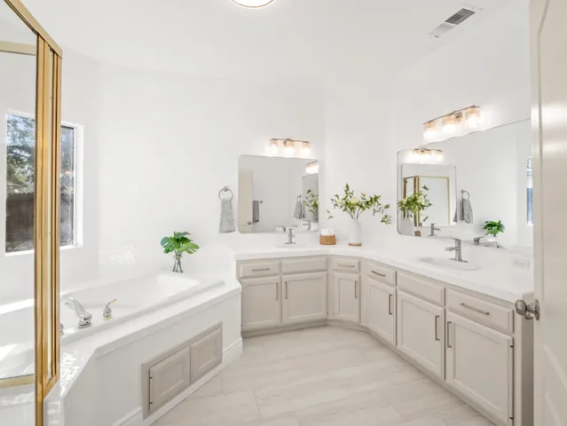 a spacious bathroom with a granite countertop sink and a mirror