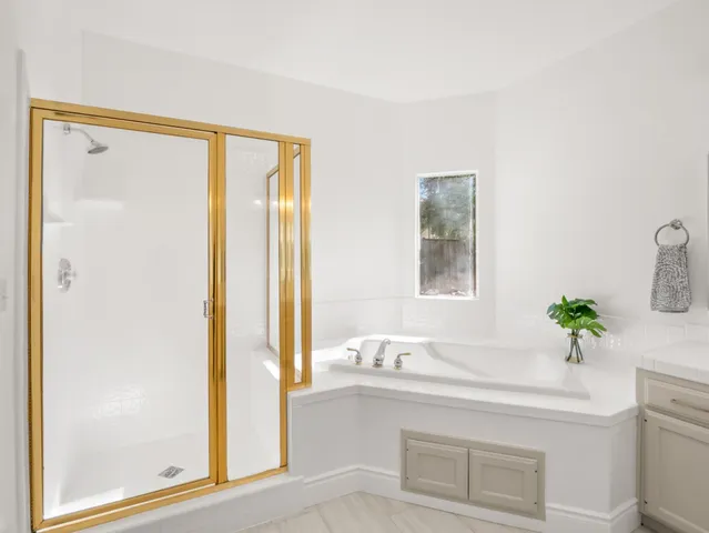 a bathroom with a granite countertop sink a mirror and a shower