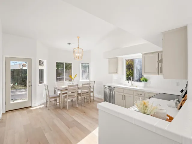a living room with furniture and a dining table with wooden floor