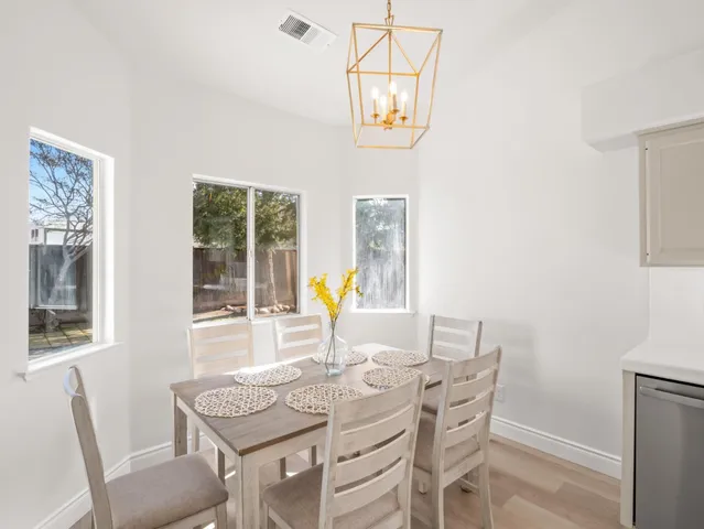 a view of a dining room with furniture a chandelier and wooden floor