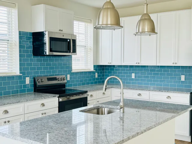 a kitchen with granite countertop a sink and a stove top oven