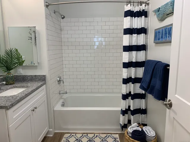 a bathroom with a granite countertop sink a toilet and mirror