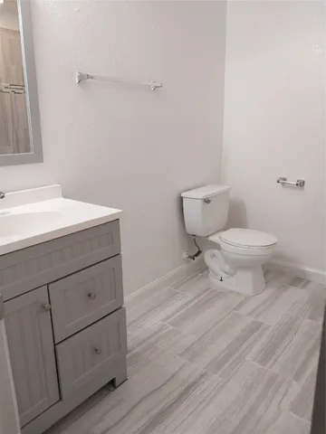 a bathroom with a toilet sink and a mirror
