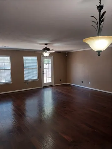 a view of a livingroom with wooden floor and a chandelier
