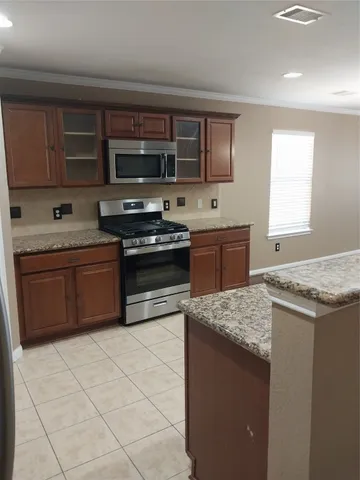 a kitchen with stainless steel appliances granite countertop a stove a sink and a microwave