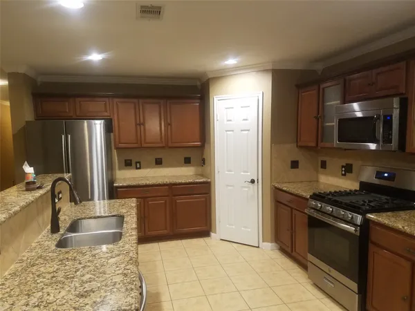 a kitchen with stainless steel appliances granite countertop a sink stove and refrigerator