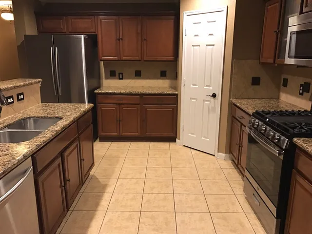 a kitchen with stainless steel appliances granite countertop a sink stove and refrigerator