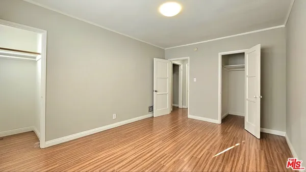 a view of an empty room with wooden floor