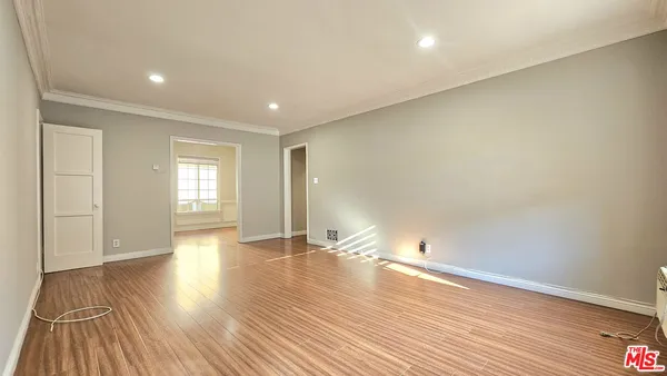 a view of empty room with wooden floor