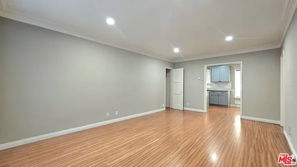 a view of an empty room with wooden floor
