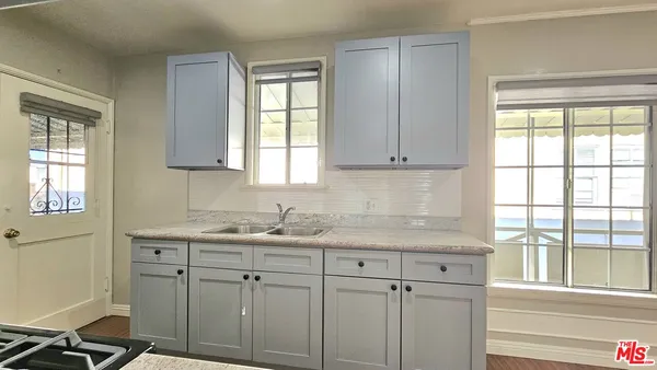 a kitchen with white cabinets and a window