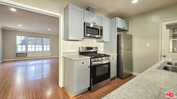 a kitchen with stainless steel appliances granite countertop a stove a refrigerator and a microwave