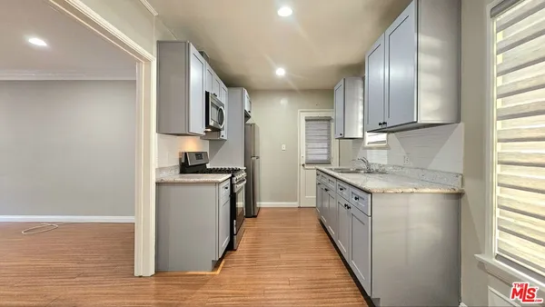 a kitchen with granite countertop a sink and stainless steel appliances