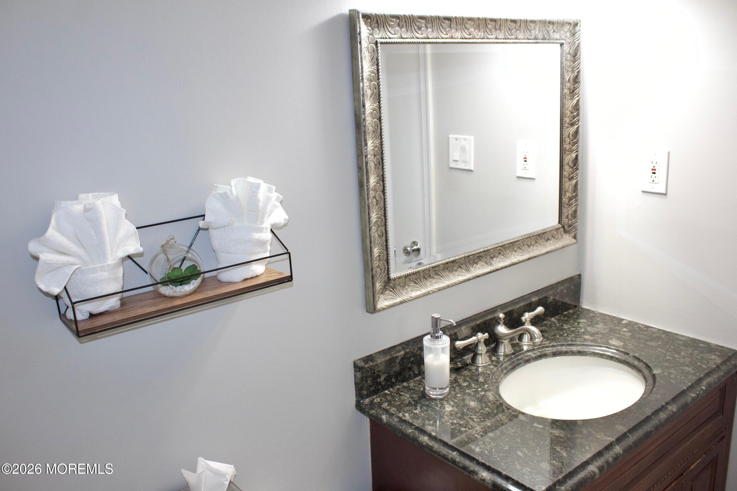 33 Balmoral Court Matawan, NJ 07747 - Photo 3 of 20 a bathroom with a granite countertop sink and a mirror