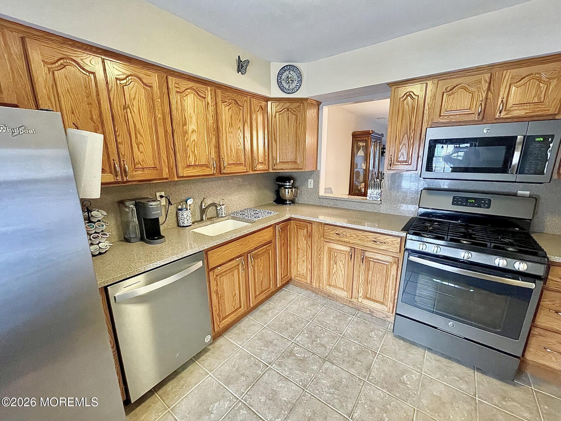 33 Balmoral Court Matawan, NJ 07747 - Photo 4 of 20 a kitchen with stainless steel appliances granite countertop a stove a sink and a refrigerator