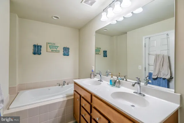 a bathroom with a sink a tub and a mirror