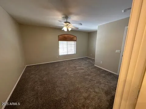 an empty room with windows and chandelier fan