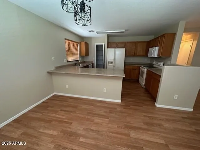 a kitchen with kitchen island a stove a sink a refrigerator dining table and chairs