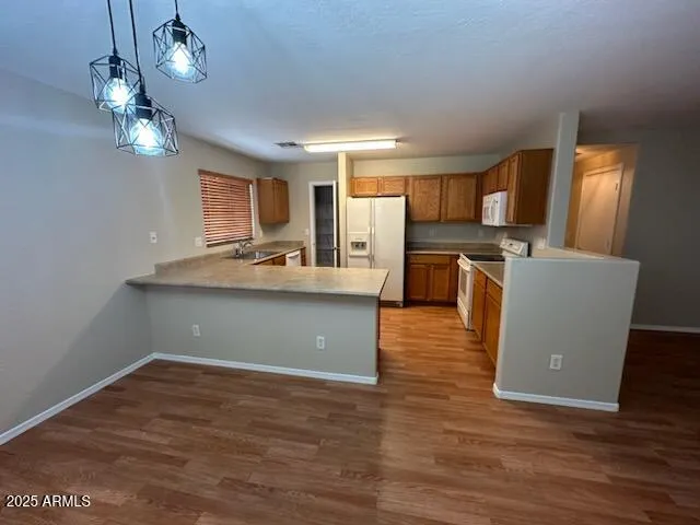 a room with wooden floor and black chairs