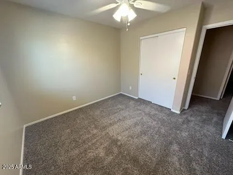 an empty room with a chandelier fan