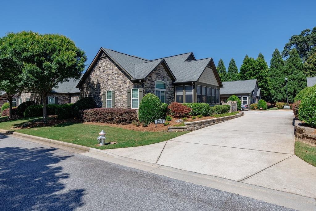 120 Chastain Road Northwest, Unit 1002 Kennesaw, GA 30144 - Photo 2 of 35 a front view of a house with a yard and garage