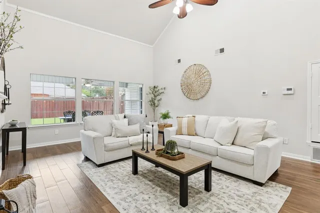 a living room with furniture a table and a large window
