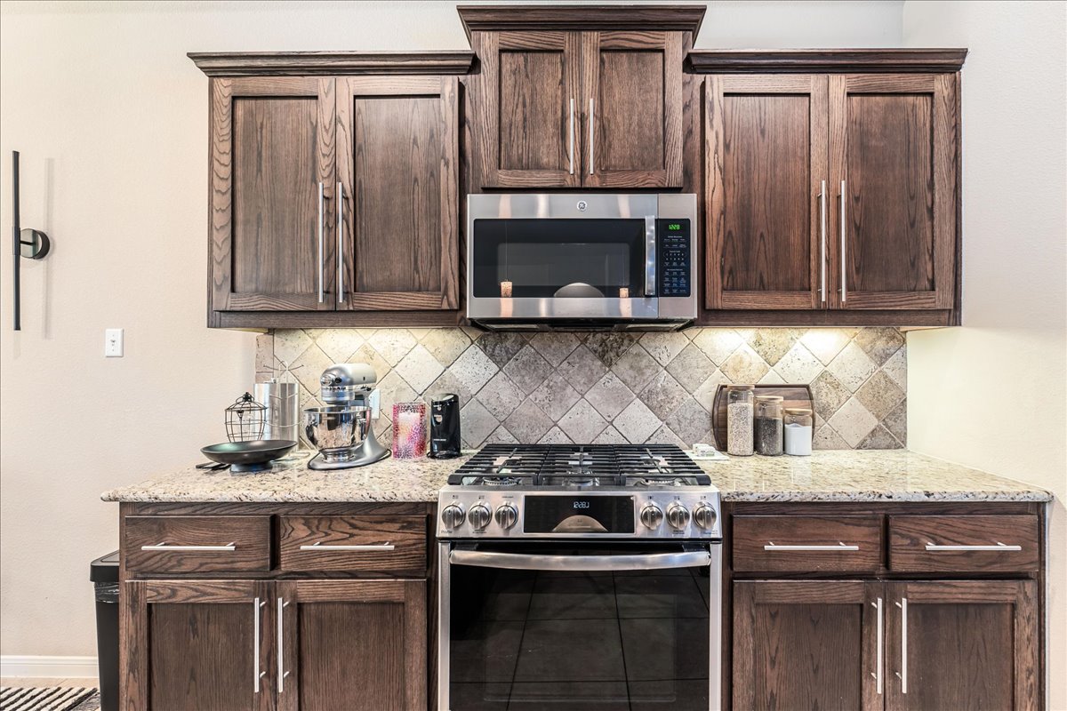 137 Navigator Drive Austin, TX 78717 - Photo 9 of 18 a kitchen with granite countertop a stove and a sink