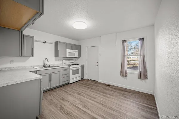 a large kitchen with cabinets wooden floor and stainless steel appliances