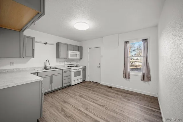 a large kitchen with cabinets wooden floor and stainless steel appliances