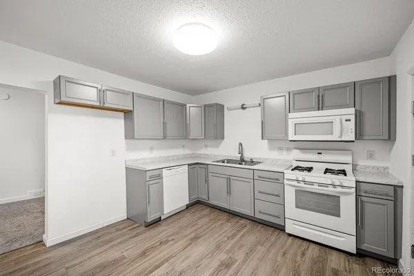 a kitchen with white cabinets and white appliances