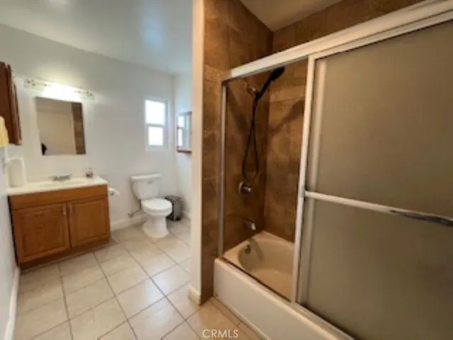 a bathroom with a granite countertop sink a toilet and shower
