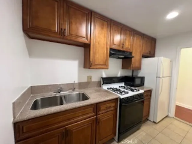 a kitchen with stainless steel appliances wooden cabinets sink and stove