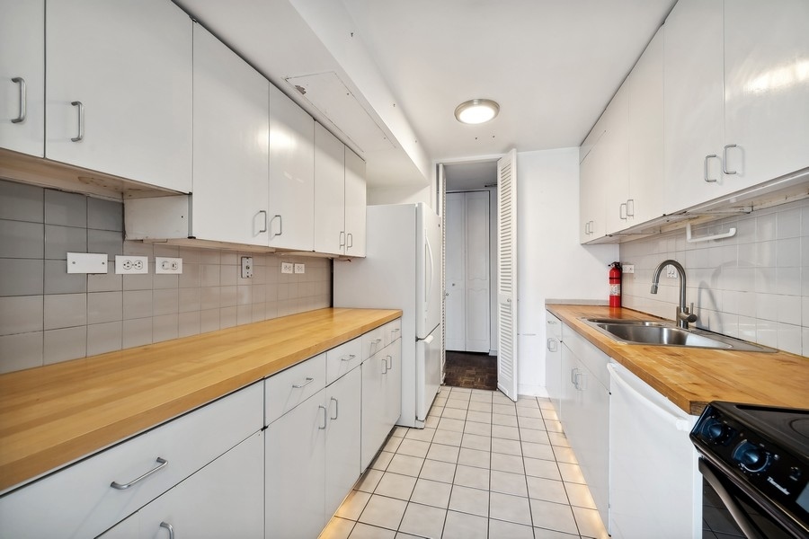 1310 North Ritchie Court, Unit 27B Chicago, IL 60610 - Photo 6 of 31 a large kitchen with stainless steel appliances granite countertop a sink stove and cabinets