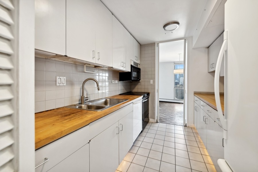 1310 North Ritchie Court, Unit 27B Chicago, IL 60610 - Photo 7 of 31 a kitchen with stainless steel appliances granite countertop a sink stove and cabinets