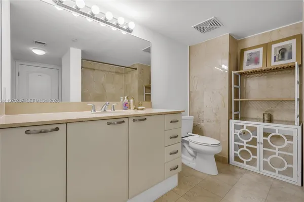 a bathroom with a double vanity sink toilet and a mirror