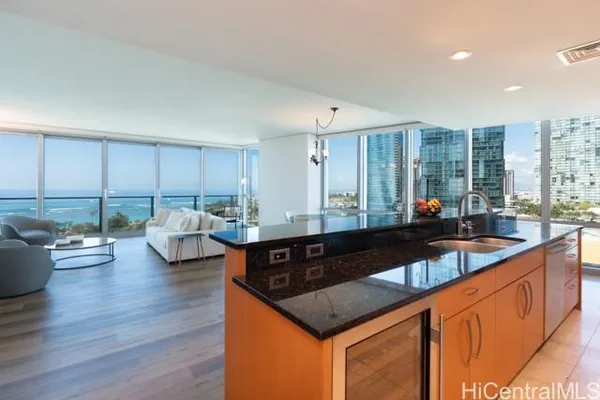 a kitchen with granite countertop a sink a counter top space and living room view