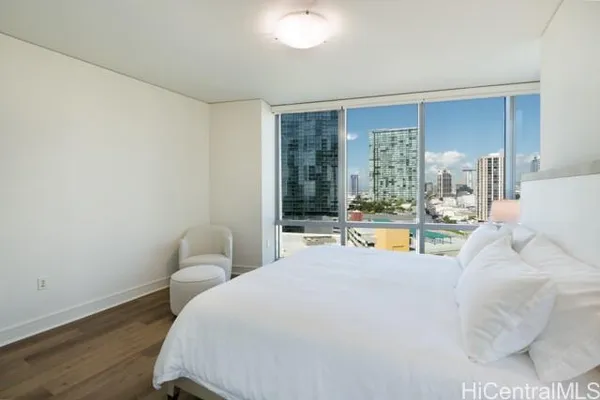 a large bedroom with a bed and large windows