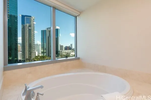 a white bath tub sitting in a bathroom next to a window