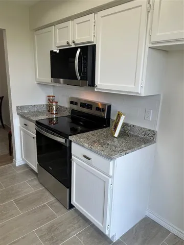 a kitchen with a stove sink and cabinets
