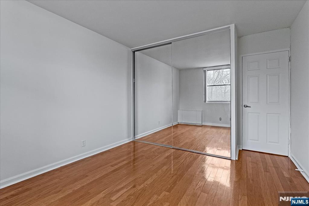 530 Valley Road, Unit C003L Montclair, NJ 07043 - Photo 18 of 25 an empty room with wooden floor and windows