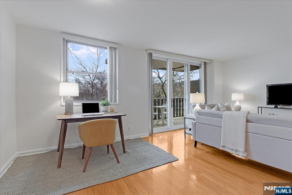 530 Valley Road, Unit C003L Montclair, NJ 07043 - Photo 8 of 25 a living room with furniture a flat screen tv and a window