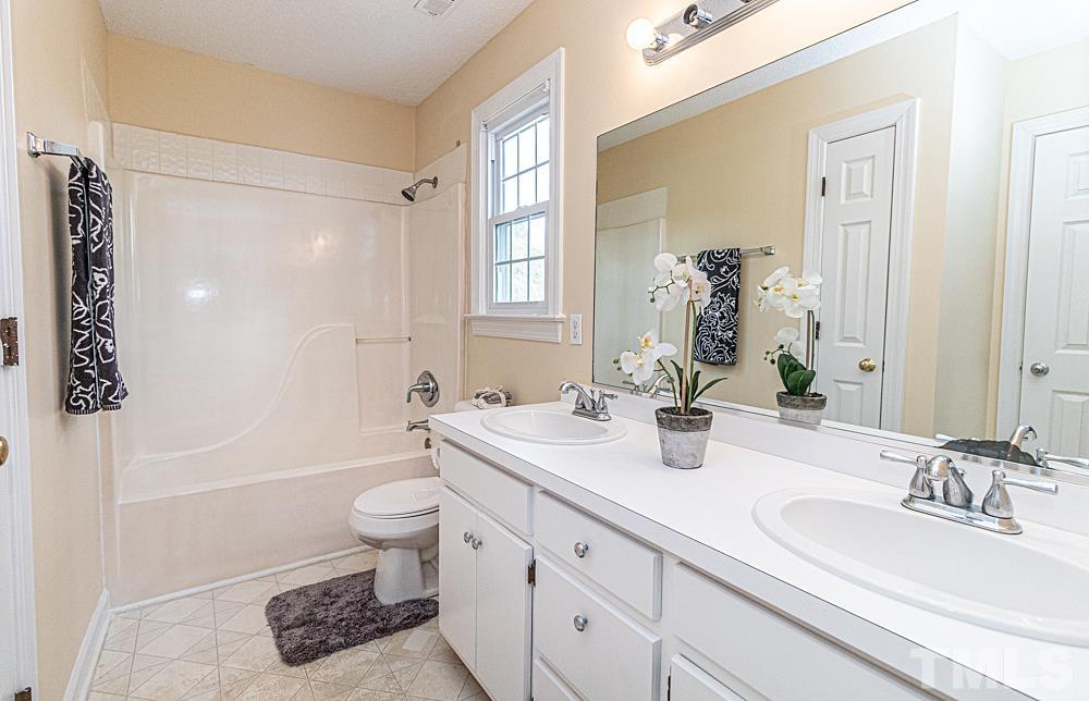 1875 Forest Wood Road Rocky Mount, NC 27804 - Photo 8 of 17 a bathroom with a granite countertop sink a toilet a mirror and shower