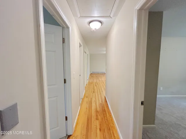 a view of a hallway with wooden floor